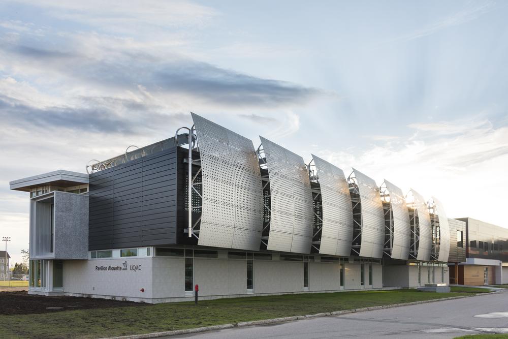 A convention center with concrete aesthetic cladding from Nichiha’s fiber cement cladding product line. Large, steel, rounded panels stick out from the sides.