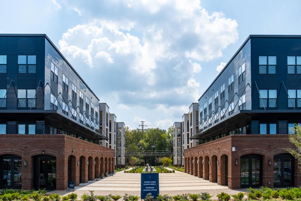 A multifamily apartment complex utilizing brick textures and sleek design with Nichiha’s fiber cement cladding. The complex is split by an open plaza.
