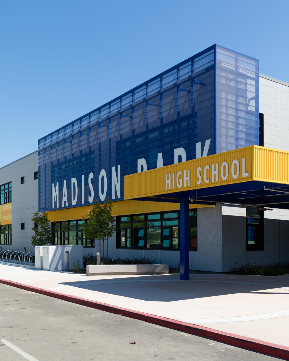 A shot of Madison Park High School using Nichiha’s fiber cement cladding in gray from the concrete series with the colors yellow and blue as accents.