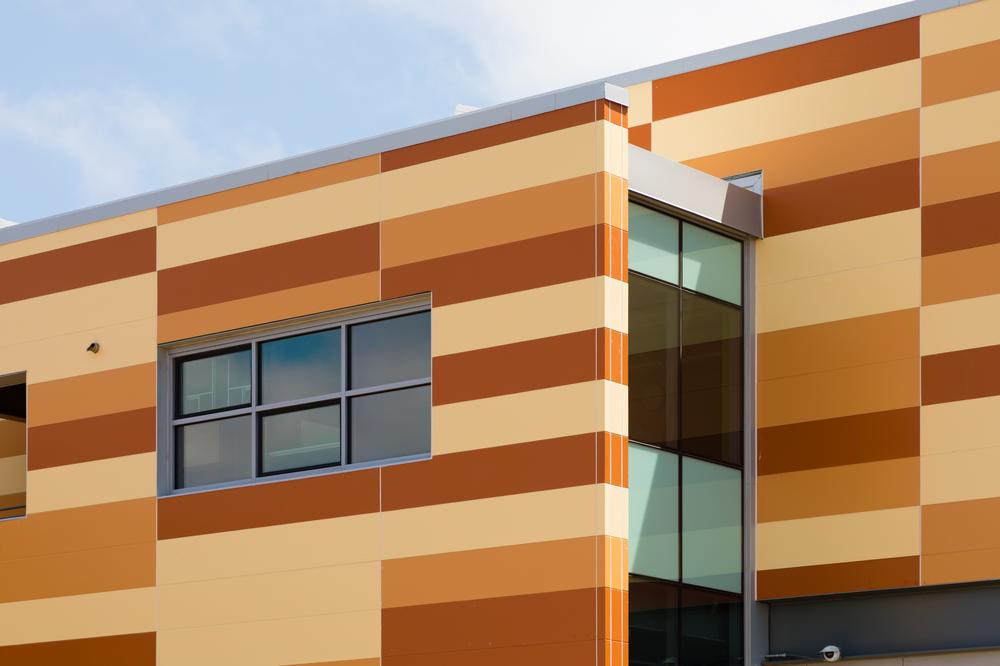 A close-up shot of Hayward High School utilizing Nichiha’s Illumination fiber cement cladding in three different shades of orange.