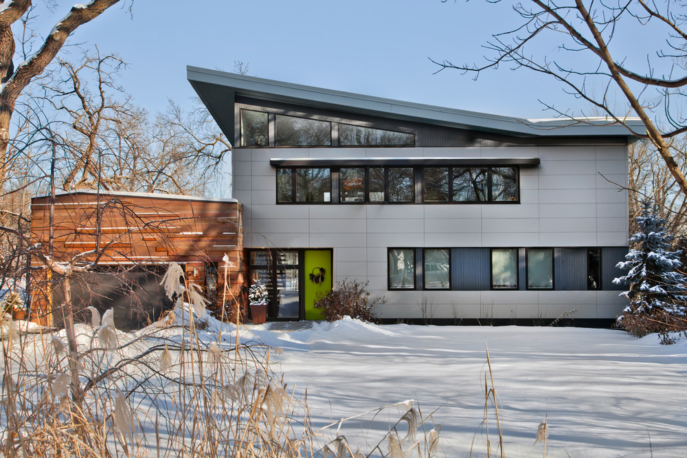 Modern home with large gray horizontal siding and pointed, sloped roof.