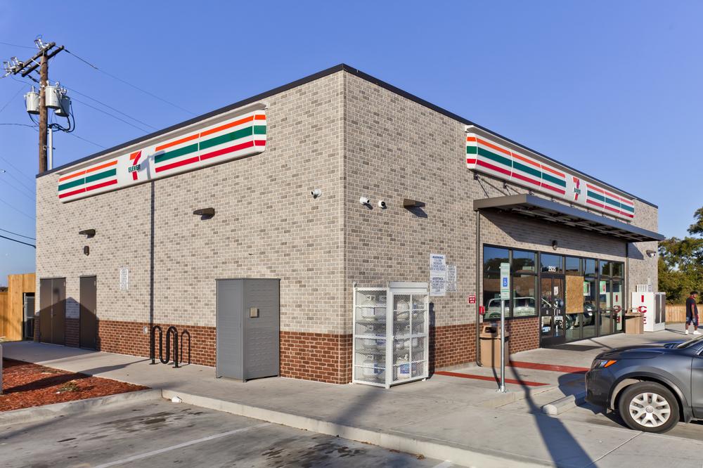 A 7-Eleven store front with light brown brick and a section of red brick lining the bottom.