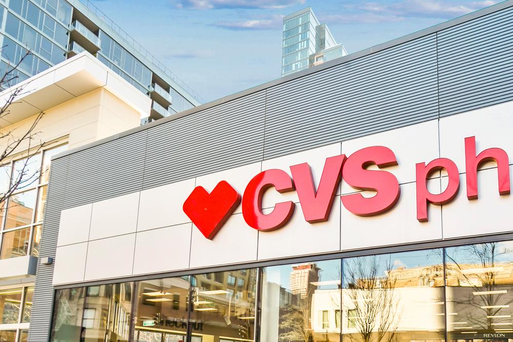 The corner of a CVS pharmacy gray, ribbed fiber cement cladding on the perimeter and white cladding behind the red logo.