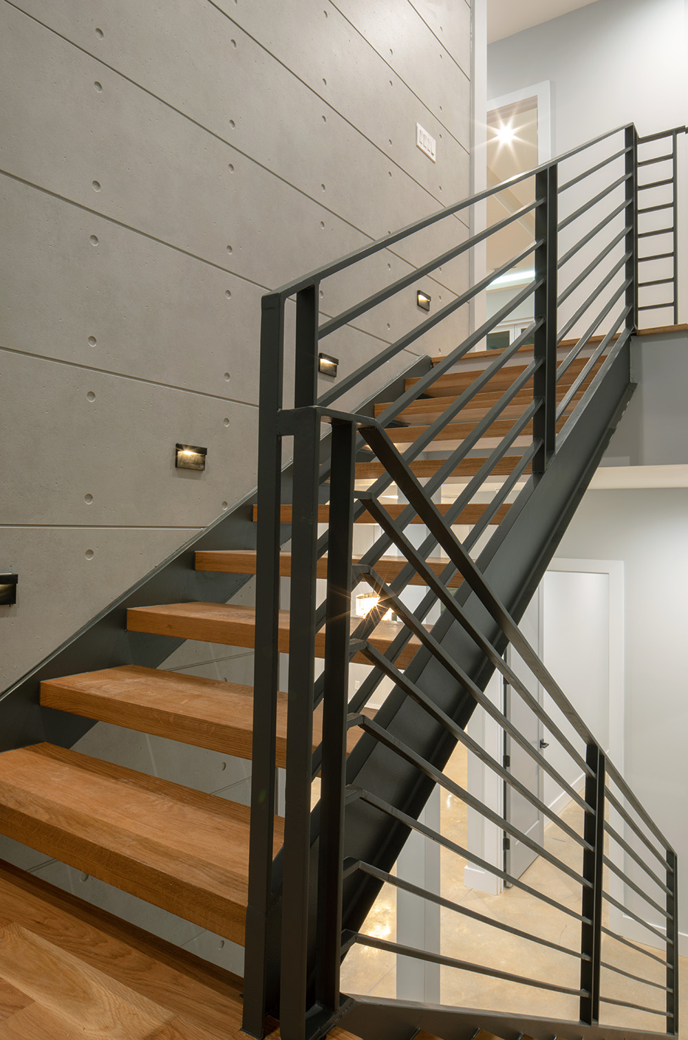 Modern staircase with black hand rails wooden steps and EmpireBlock on the wall