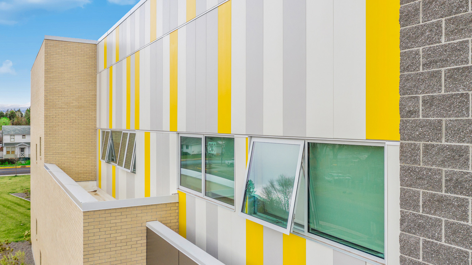 Side of Franklin School in Montana featuring yellow and gray Illumination panels and an open window