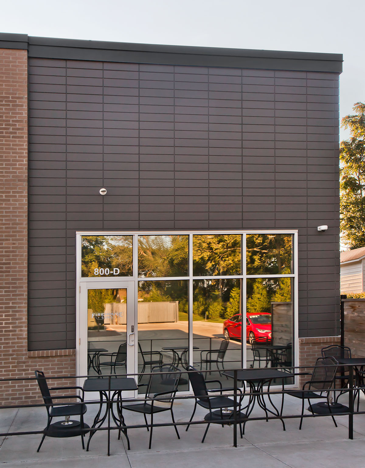 Retail space with Novenary in slate with tables and chairs on the patio in front